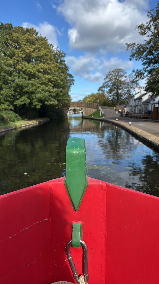 View from the bow approaching a canal bridge near a pub