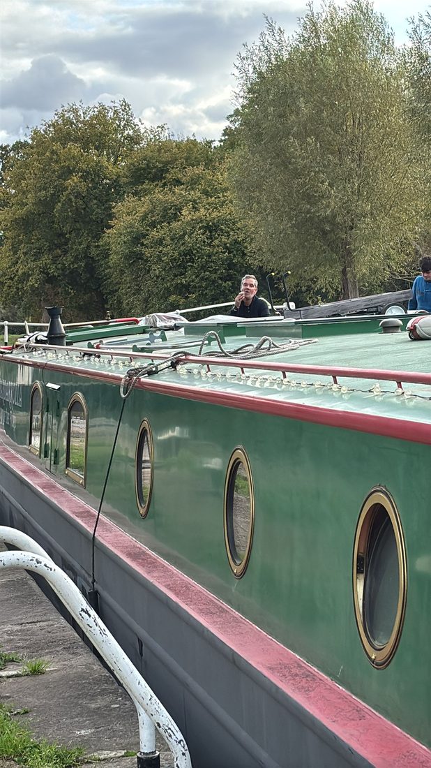 Close view of the boat's brass-rimmed portholes and roofline